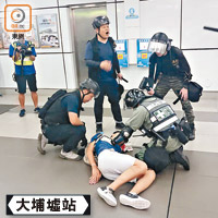 一名男子被警員制服地上，頭部疑遭扑爆流血。（楊日權攝）