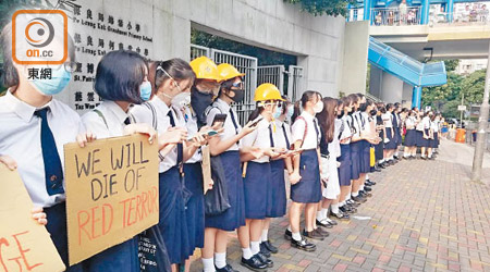 慈雲山學校村學生築人鏈持紙牌表達訴求。（馮淑環攝）