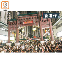 香港仔廣場內坐滿市民，部分人舉起手機電筒。（袁以諾攝）