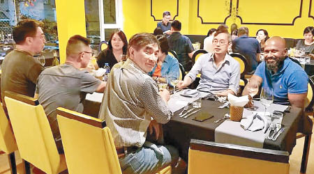 鍾國斌（前排右）同業界邊食飯邊交流。（互聯網圖片）