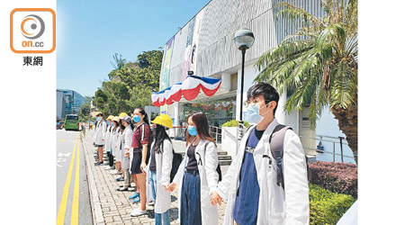 約六十名醫學院學生昨趁新生白袍典禮舉行前於會場外築成人鏈。（陳宛彤攝）