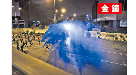 水炮車向政總外的示威者噴射藍色染劑。（美聯社圖片）