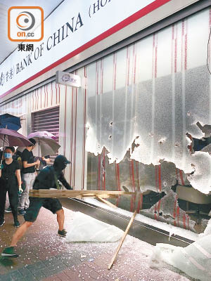 油麻地<br>有示威者用木梯破壞中銀的玻璃。