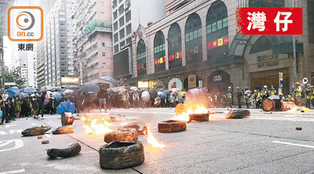 示威者在行車路上放滿地磚並放火燒車胎。（朱偉坤攝）