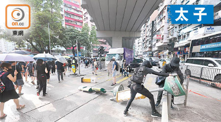 有黑衣蒙面人破壞路邊小巴站路牌。（高嘉業攝）