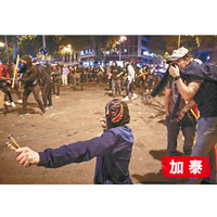 蒙面的示威者以彈弓攻擊警員。（美聯社圖片）