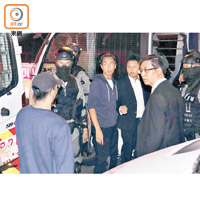 警方用警車帶走獲釋的被告丘建威（左）。（袁志豪攝）
