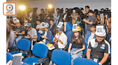 六名記者戴上貼有字的頭盔抗議。（李志湧攝）