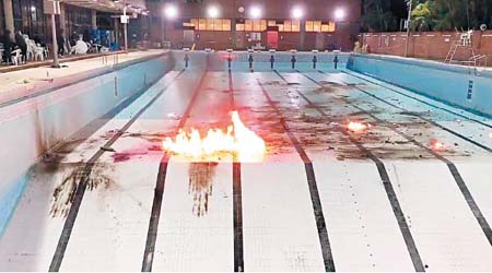 被抽乾水的泳池遭不斷掟汽油彈，不時燃起熊熊火光。（互聯網圖片）