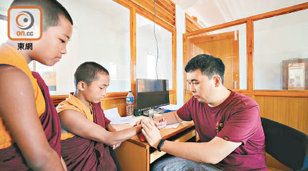 歐卓榮（右）為尼泊爾兒童把脈。（受訪者提供）