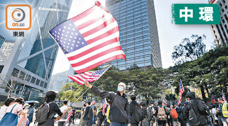 昨日有遊行人士揮動美國國旗感謝《人權法案》獲通過。（袁志豪攝）