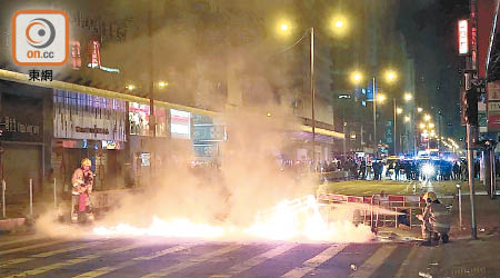 示威者深夜在旺角燒雜物堵路，消防忙於撲火。