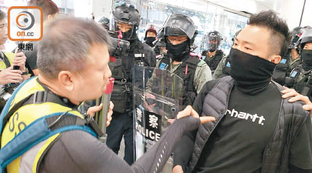 有警員（右）前日在大埔超級城截查一名記者時，在直播鏡頭前展示記者（左）的身份證。