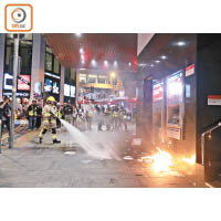 中環<br>消防員在滙豐銀行外撲熄火種。