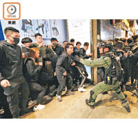 一批黑衣人與防暴警呈對峙之勢。