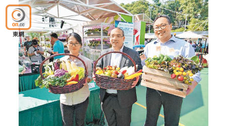 本地漁農美食嘉年華籌委會主席劉堅偉（中）展示本地農產品。