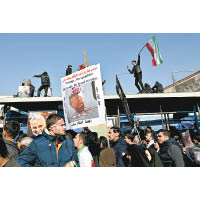 伊朗民眾高舉反特朗普標語牌。（美聯社圖片）