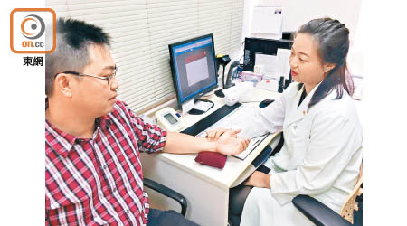 中醫師徐逸芝（右）進行天灸療法前為病人把脈。（區慧盈攝）