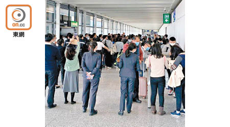 大批由武漢抵港的旅客需排長龍填寫健康申報表及量體溫。（讀者提供）