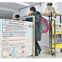 來自武漢的旅客通過成田機場的檢疫站。（美聯社圖片）
