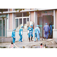 武漢的醫院職員清洗出入口。（美聯社圖片）
