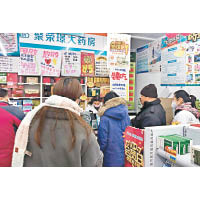 民眾在一家藥店排隊購買口罩等防護用品。（中新社圖片）