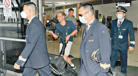 中國東航機組人員步出悉尼機場時均戴上口罩。（美聯社圖片）