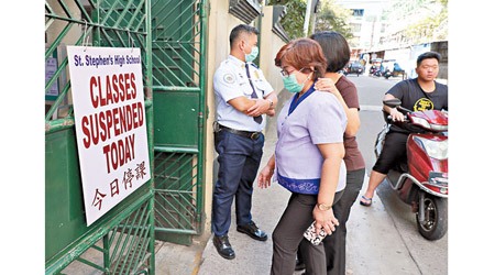 菲律賓：菲律賓的教師戴口罩進入華人學校。（美聯社圖片）
