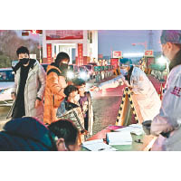 山西省太原市迎西高速收費站出口，工作人員對司機及乘客進行體溫檢測。（中新社圖片）