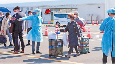 穿上保護衣的曾國衞（箭嘴示）在日本協助滯留港人。（受訪者提供）