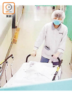 醫院職員將女嬰遺體舁送殮房。（梁裔楠攝）