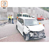 私家車車頭嚴重損毀，橫亘於路中。