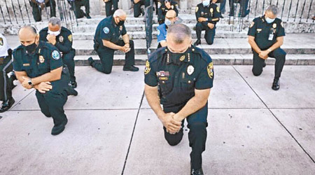 佛羅里達州：佛羅里達州警員單膝跪下，悼念死者。