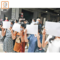 多名市民舉起白紙目送被告離開。