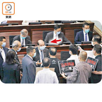 張建宗（箭嘴示）被民主派議員包圍，要求政府協助十二人蛇的家屬。（李志湧攝）