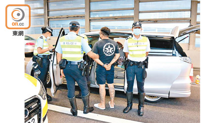 警員押解紋身司機搜查七人車。（梁穎福攝）