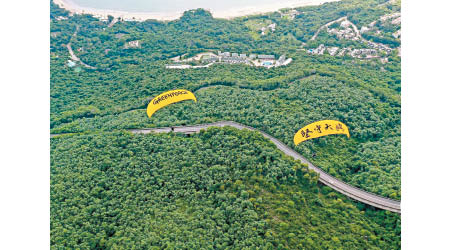 綠色和平兩名飛行員的滑翔傘寫有「堅守大嶼」字樣。