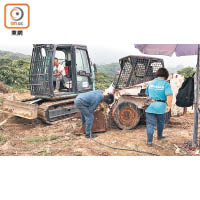 工人將一輛霸佔官地的挖泥車切割。