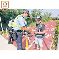 警員向駕單車者派傳單。