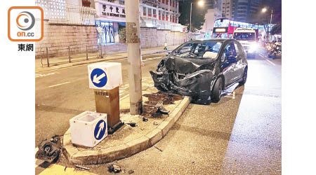 私家車失控剷安全島後漏油，司機及乘客逃去。（胡德威攝）