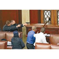 國會警員擎槍指向議事廳門外的示威者。（美聯社圖片）