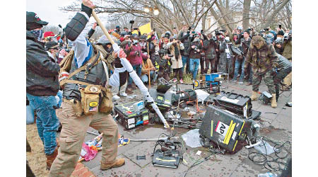 不滿CNN的示威者大肆毀壞美聯社的採訪器材。（美聯社圖片）