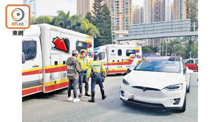 肇事Tesla停在現場，警員向私家車男司機（箭嘴示）了解經過。（蘇偉明攝）