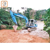本報發現該藍色挖泥車曾在去年11月將違建道路上的石屎鑿開。