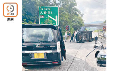 私家車翻側橫亘路中。