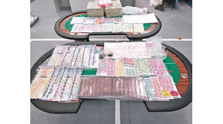 警方展示檢獲的證物，包括兩張百家樂賭枱。