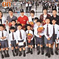 中國羽毛球隊昨抵埗，在機場受到一班學生獻花迎接。