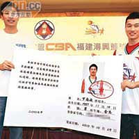 從潯興教練朱世龍（左）手中接過特大球員證。