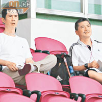 剛接任港隊教練嘅廖俊輝（左）同離任嘅曾偉忠，喺看台睇住班U21輸波，冇晒心機。