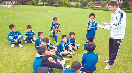 車路士教練（右）悉心教導一班足球小將。